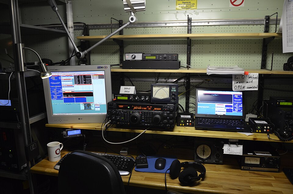 Estación de radioaficionado durante un concurso HF — transceptores, pantallas y equipos de operación